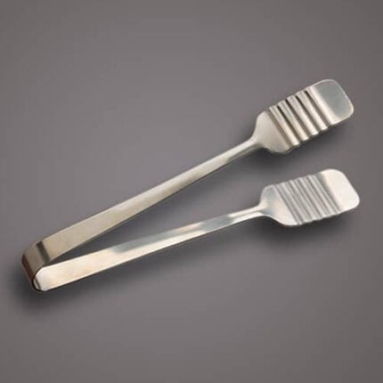 Stainless steel tongs for food handling on gray background.