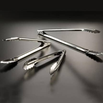 Stainless steel tongs on a dark surface, ideal for food handling and hygiene.