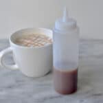 Cream coffee with caramel syrup in a white ceramic mug, served on a marble surface, highlighting premium beverage offerings by Beyond Hygiene Asia.