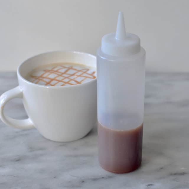 0048192_2.jpg Cream coffee with caramel syrup in a white ceramic mug, served on a marble surface, highlighting premium beverage offerings by Beyond Hygiene Asia.