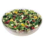 Fresh mixed green salad with cherry tomatoes and yellow bell peppers in a glass bowl for healthy eating.