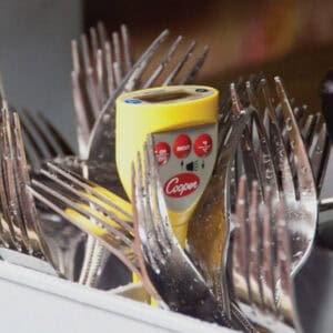 Disinfectant tester surrounded by dirty forks for food safety and hygiene in restaurant setting.