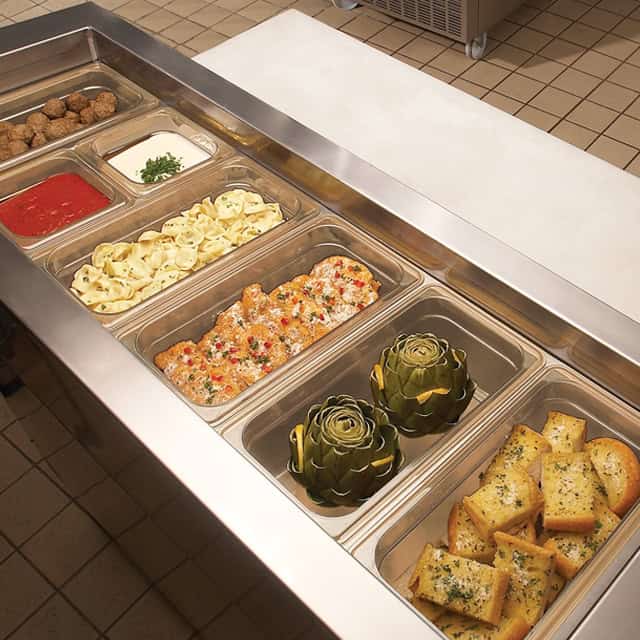 1016539_2.jpg Freshly prepared Italian pasta, artichokes, and garlic bread on a stainless steel buffet station for catering and food service.