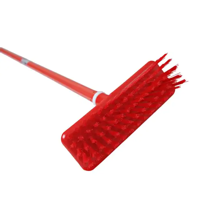 Red cleaning scrub brush with long handle for industrial sanitation and surface cleaning.