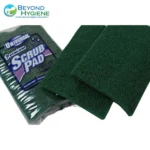 Scrub pads inside plastic packaging, green abrasive cleaning tools for professional hygiene maintenance.