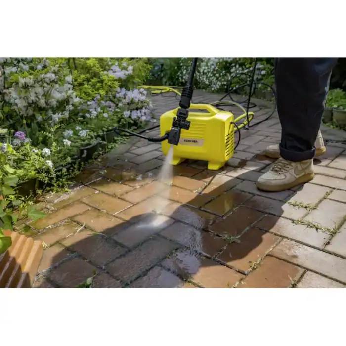 Powerful pressure washer cleaning brick patio outdoors, garden, spring cleaning, Beyond Hygiene Asia promotional image, high-pressure water jet removing dirt and grime, eco-friendly cleaning solution.