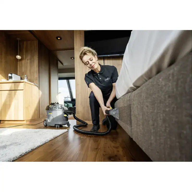 puzzi-8-1-eu (1) Deep cleaning of a hotel room mattress by professional staff using industrial vacuum cleaner for hygiene and sanitization.
