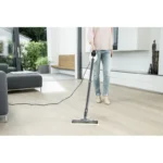 Vacuum cleaner in a modern living room, cleaning hardwood floor for hygiene and cleanliness.