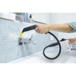 Disinfecting a bathroom sink faucet with a professional steam cleaner for sanitation and hygiene.