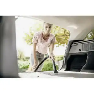 Vacuum cleaner being used to clean car trunk outdoors, professional cleaning service, beyond hygiene asia, vehicle sanitation, eco-friendly cleaning solution, high-quality hygiene maintenance, car interior cleaning service.