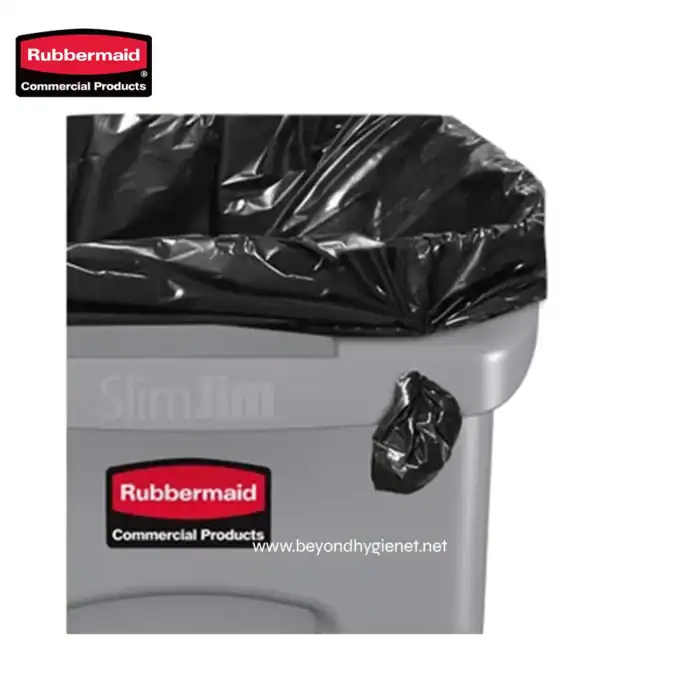 Black trash bag liner over a commercial Rubbermaid trash bin, emphasizing waste management solutions.