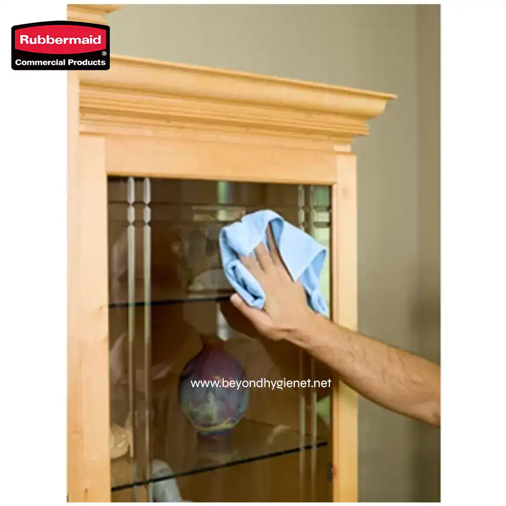 3 Rubbermaid commercial cleaning supply being used to disinfect a wooden display cabinet, highlighting professional sanitization and hygiene practices.