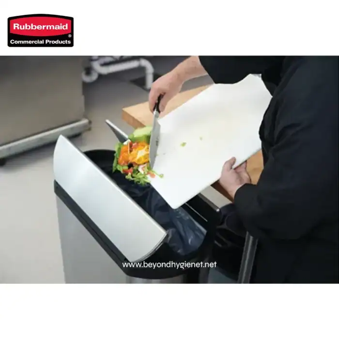 Fresh salad being discarded into a Rubbermaid commercial trash bin, highlighting hygiene and waste management practices for food venues.