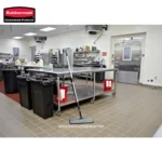 Rubbermaid commercial cleaning cart and equipment in a professional kitchen setting, emphasizing hygiene and sanitation solutions for food industry environments.
