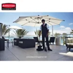 Cleaning service staff disinfecting outdoor patio furniture with vacuum and cleaning tools at a commercial cleaning site.