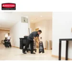 Rubbermaid commercial cleaning staff with cleaning cart in a hotel corridor.