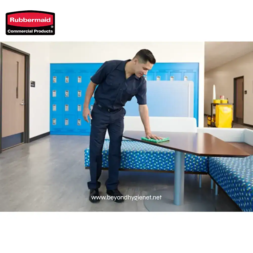 4 Disinfecting a table with cleaning spray in a commercial space for hygiene maintenance.