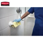 High-quality cleaning of shower walls using disinfectant in a commercial bathroom, demonstrating hygiene protocols and professional sanitation practices for optimal cleanliness.