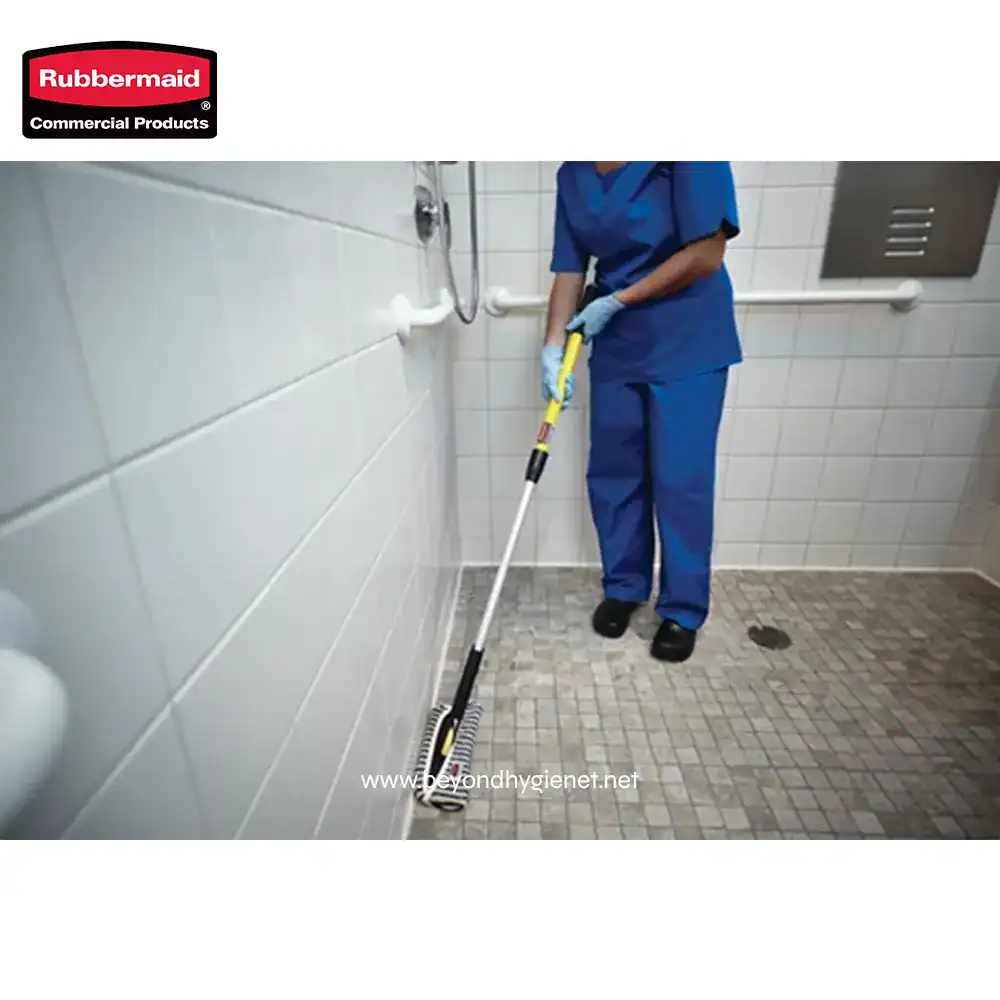 5 Rubbermaid commercial cleaning tools being used in a well-maintained restroom for sanitation and hygiene.