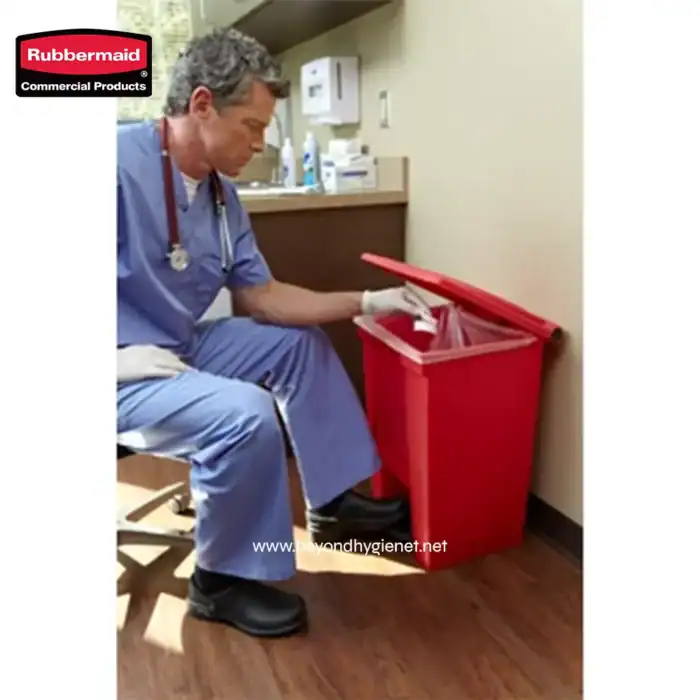 Red medical waste disposal bin in a healthcare setting, used for proper disposal of sharps and contaminated materials to maintain hygiene and safety.