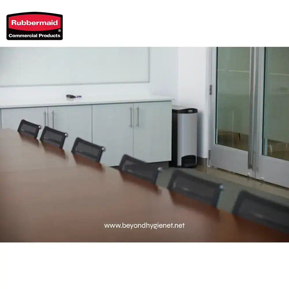 7 Rubbermaid commercial cleaning supplies in a modern office conference room setting.