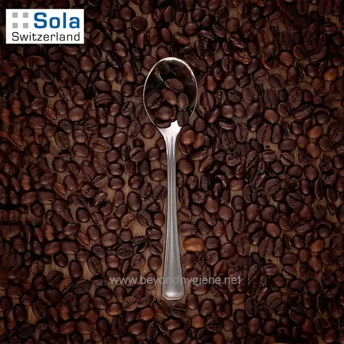 Coffee beans with a metal spoon on a wooden surface, close-up shot for coffee shop or beverage business SEO.