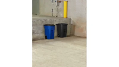 Blue and black waste bins in an industrial or commercial cleaning setting, emphasizing waste management and hygiene practices.