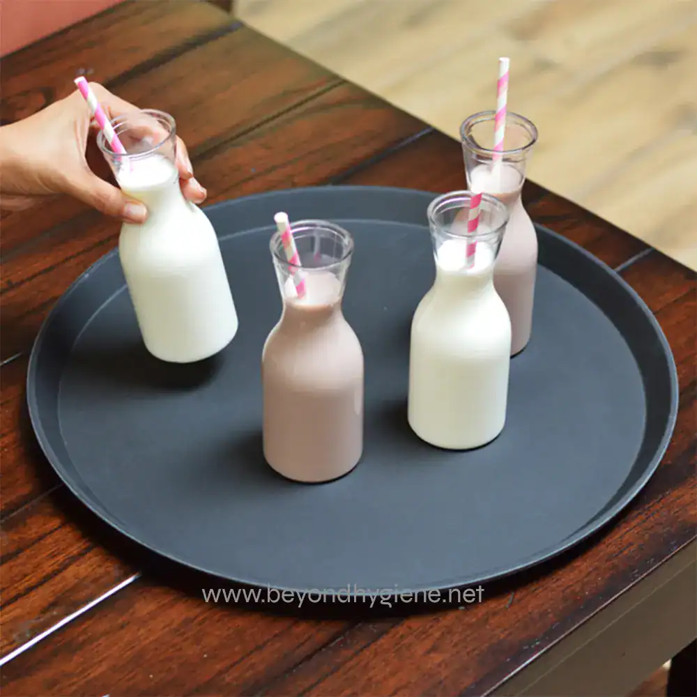 0048508_2 Milk bottles with straws on a black tray, served for a beverage drink, in a hygienic and clean setting.