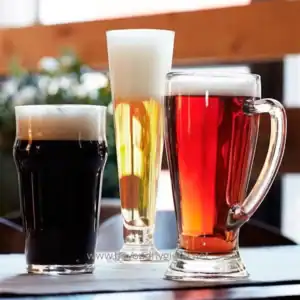 Cold beer and craft beverages served in various glassware at a bar or restaurant. Perfect for promoting hygiene and cleanliness standards in food service settings.