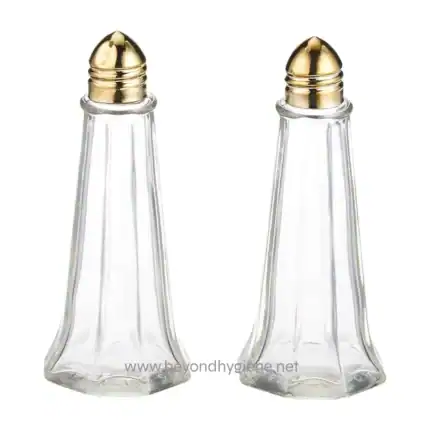 Glass salt and pepper shakers with gold accents, perfect for restaurant or home dining, showcasing hygiene and elegance in table setting.