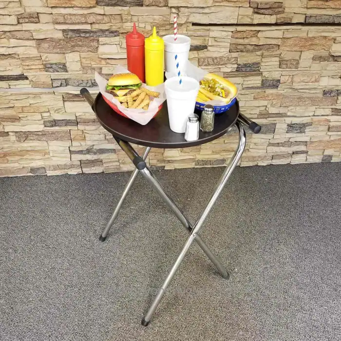 Kitchen table with fast food including burger and fries, condiments, and beverages, in a casual restaurant setting.