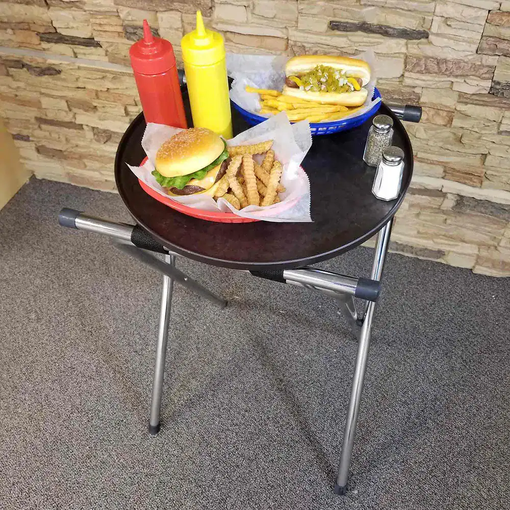 12 Fresh fast-food meal on a black table with ketchup and mustard bottles, consisting of a burger, fries, and hot dog, with salt and pepper shakers, in a casual dining or restaurant setting.