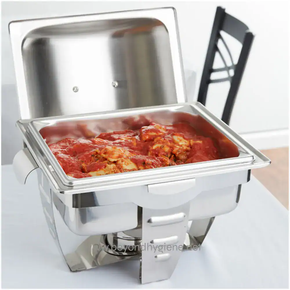 1208620 Stainless steel chafing dish with hot cooked chicken in tomato sauce, often used in food service and catering for maintaining warm, hygienic buffet-style meals.