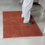 Non-slip red rubber cleaning mat for hygienic safety in commercial kitchens and food service areas.