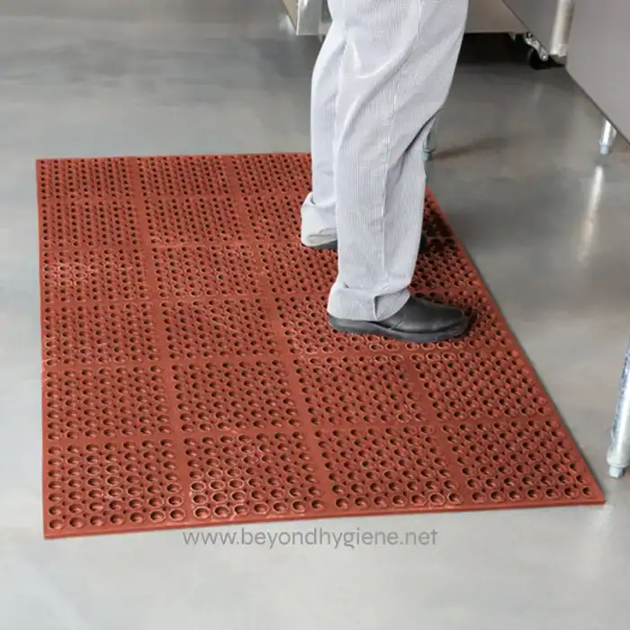 Non-slip red rubber cleaning mat for hygienic safety in commercial kitchens and food service areas.
