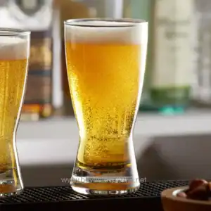 Golden beer in tall glass with foam head, refreshing beverage, served at Beyond Hygiene Asia, emphasizing sanitation and hygiene standards.