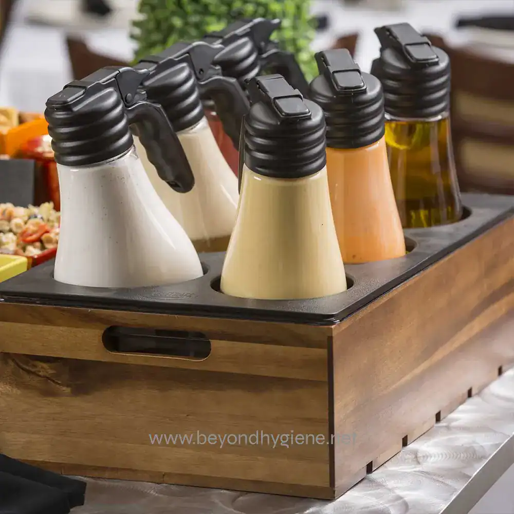 3 Cream and salad dressing squeeze bottles in a wooden condiment caddy at Beyond Hygiene Asia.