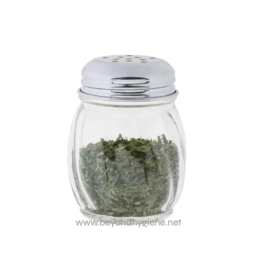 Fresh dried herbs in a glass jar with a metal shaker top, suitable for culinary and medicinal use, showcasing premium quality herbs from Beyond Hygiene Asia.