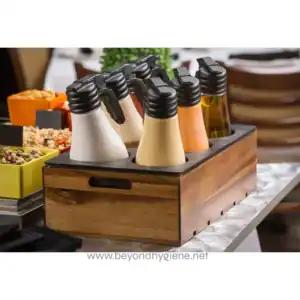 Fresh dark syrup in glass syrup dispenser with metal lid, suitable for breakfast or dessert toppings, with fresh fruit and pastries in the background.