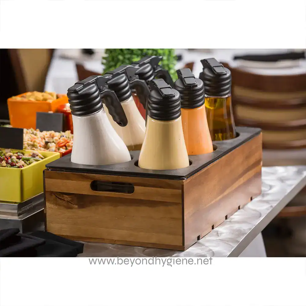 4 Assorted salad dressings and condiments in squeeze bottles on a wooden tray at a buffet station.