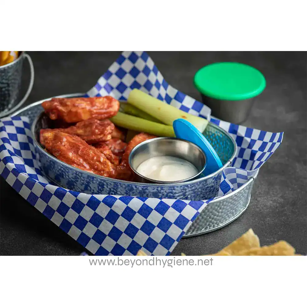 7 Crispy buffalo chicken wings served with celery sticks and dipping sauce on a checkered paper-lined basket, emphasizing food safety and hygiene standards in food presentation.
