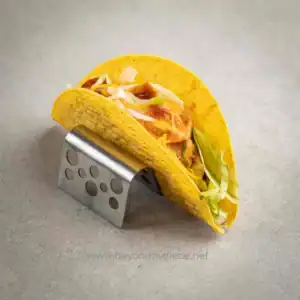 Freshly made tacos with lettuce, tomato, and cheese on yellow corn taco shells, placed on a modern metal taco holder. Perfect for enjoyably quick and hygienic meals in Asia.