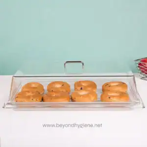 Cookies in a glass display case on a white surface with a teal background.