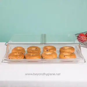 Deluxe bakery display case with glazed donuts on a white countertop, minimalistic background, showcasing hygiene standards in food presentation.