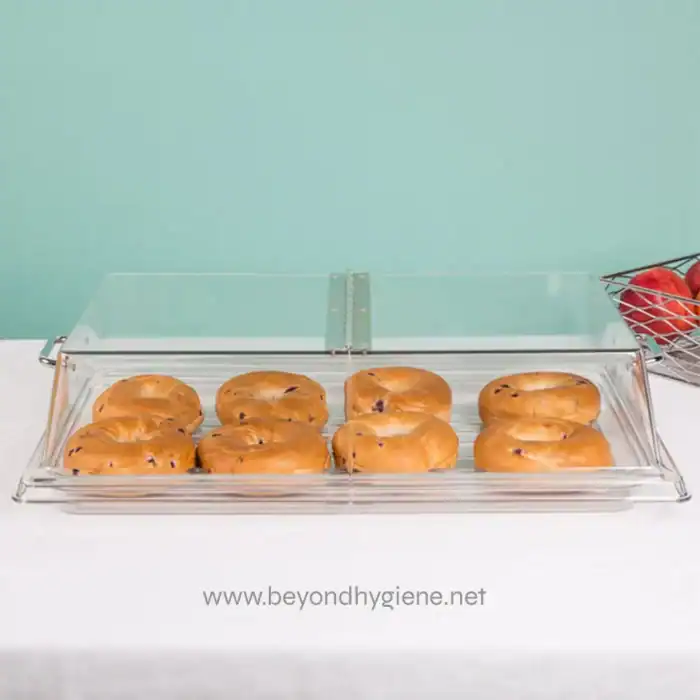 Deluxe bakery display case with glazed donuts on a white countertop, minimalistic background, showcasing hygiene standards in food presentation.