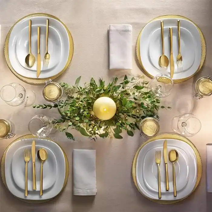 Elegant dining table setup with gold cutlery and white plates, perfect for special occasions or upscale events, highlighting hygiene and luxury standards.