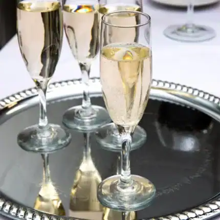 Champagne glasses filled with sparkling wine on a silver tray, celebrating special occasions. Elegant wine glasses, premium beverage presentation, luxury event essentials.