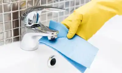 Disinfecting a faucet with a blue cleaning cloth, representing professional hygiene services for residential and commercial spaces.