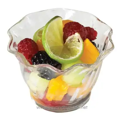 Fresh mixed fruit salad in a glass bowl with citrus slices, berries, and melons, highlighting healthy snack options and vibrant presentation.