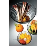 Minced artichoke hearts, radicchio, and dried herbs in a glass bowl, fresh citrus fruit, and vegetable garnishes on a white surface, showcasing healthy, fresh ingredients for catering or food presentation.